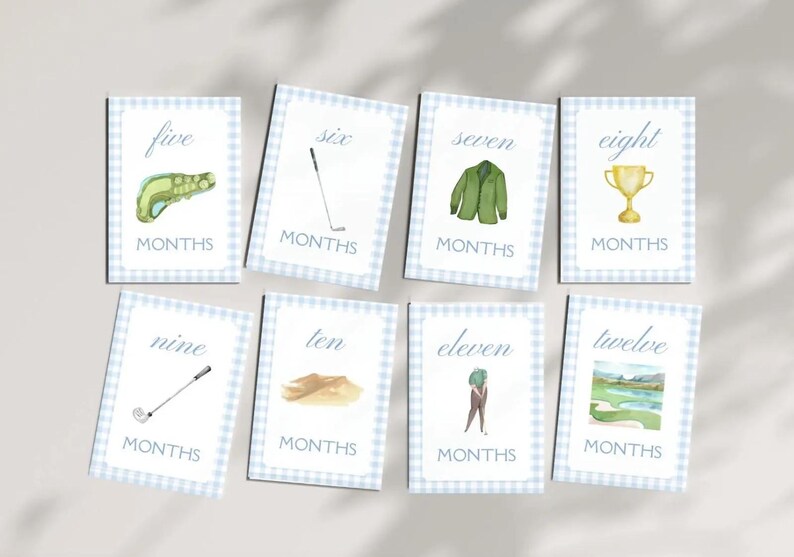 May include: Set of 10 blue and white gingham cards with golf-themed illustrations and the numbers five through twelve with the word "MONTHS" below each number.