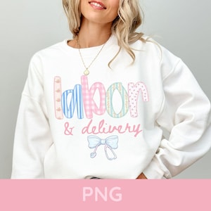 May include: White sweatshirt with the words "labor & delivery" in colorful, patterned letters. A light blue bow and stethoscope graphic is below the text. The sweatshirt is a casual, comfortable style.