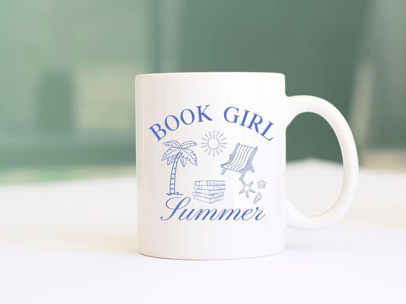 May include: White ceramic mug with a blue design featuring the words "BOOK GIRL Summer" along with illustrations of a palm tree, sun, beach chair, books, and seashells. The mug has a curved handle.