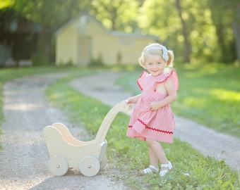 Gingham pinafore jumper dress.  Flutter sleeves and skirt with red rick rack trim. Size: 12 mo./1T, or 18 months.