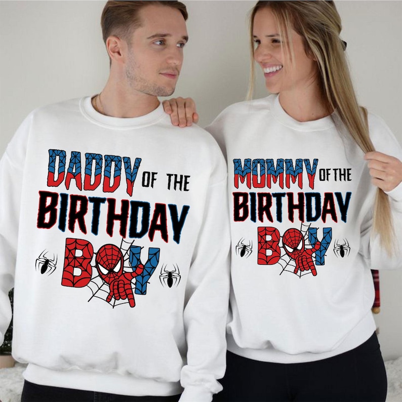May include: White sweatshirts with red and blue text that says "Daddy of the Birthday Boy" and "Mommy of the Birthday Boy".  The text is surrounded by a spider web design with a cartoon Spiderman in the center.
