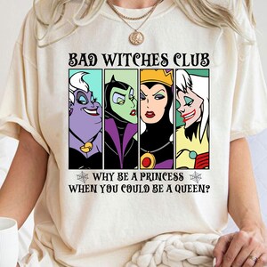Puede incluir: Una camiseta blanca con un estampado gr&aacute;fico de cuatro villanas de Disney: &Uacute;rsula, Mal&eacute;fica, la Reina Malvada y Cruella de Vil. El texto dice "Bad Witches Club" y "Why be a princess when you could be a queen?"