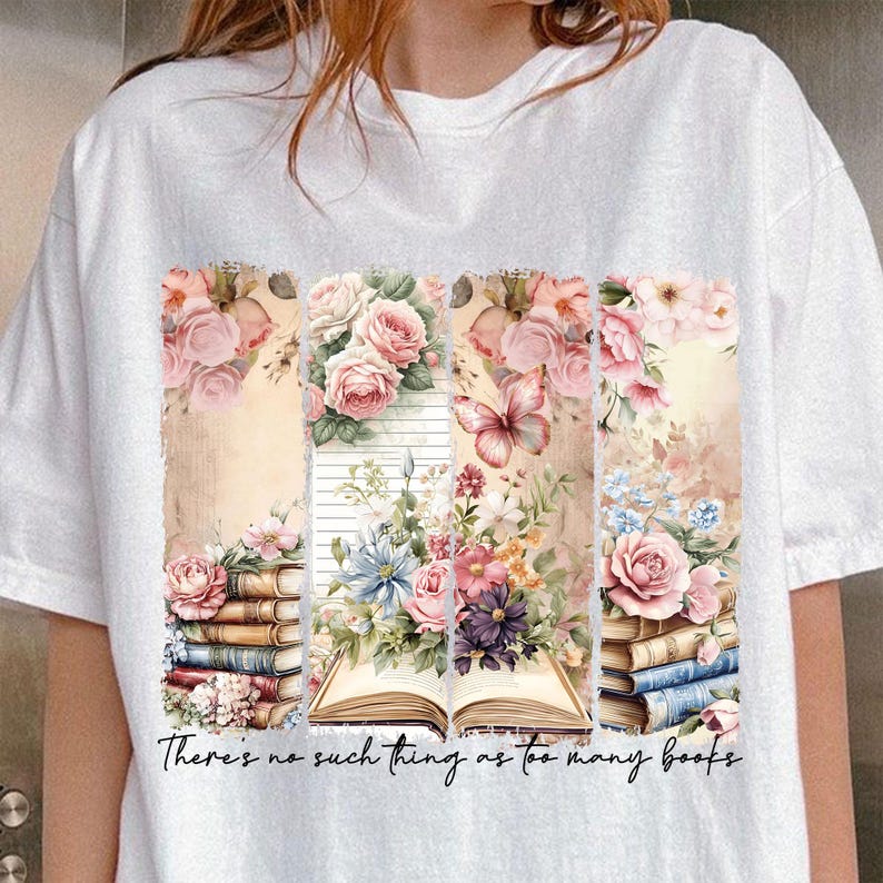 May include: White t-shirt with a floral design and stacked books. The text "There's no such thing as too many books" is printed on the bottom of the shirt.