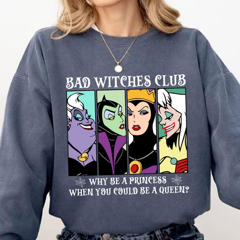 Puede incluir: Una sudadera azul oscuro con un estampado gr&aacute;fico de cuatro villanas de Disney: &Uacute;rsula, Mal&eacute;fica, la Reina Malvada y Cruella de Vil. El texto dice "Bad Witches Club" y "Why be a princess when you could be a queen?"