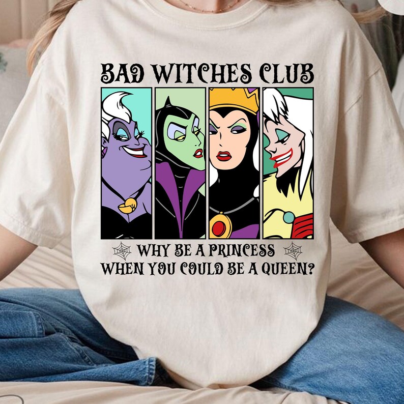 Puede incluir: Una camiseta blanca con un estampado gr&aacute;fico de cuatro personajes de villanos de Disney, &Uacute;rsula, Mal&eacute;fica, la Reina Malvada y Cruella de Vil. El texto dice "Bad Witches Club" y "&iquest;Por qu&eacute; ser una princesa cuando puedes ser una reina?"