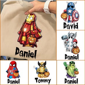 Può includere: Una felpa beige con diversi disegni di fantasmi di supereroi a tema Halloween. Ogni fantasma tiene in mano una lanterna a forma di zucca. I nomi "Daniel", "David" e "Tommy" sono stampati sotto.
