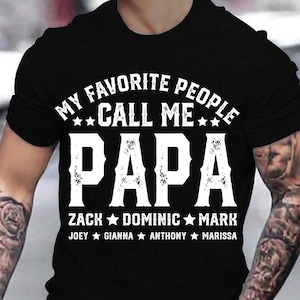 May include: Black t-shirt with white text that reads "My Favourite People Call Me Papa" with a list of names below: Zack, Dominic, Mark, Joey, Gianna, Anthony, Marissa.
