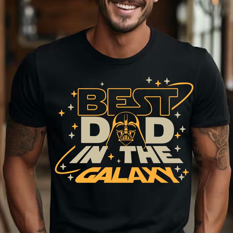 May include: Black t-shirt with a yellow graphic that says "Best Dad in the Galaxy" with a Darth Vader silhouette in the middle of the text.