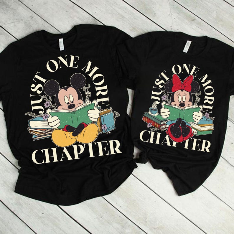 Op de afbeelding: Twee zwarte T-shirts met een afbeelding van Mickey en Minnie Mouse die boeken lezen. De tekst op de shirts luidt "Just One More Chapter".