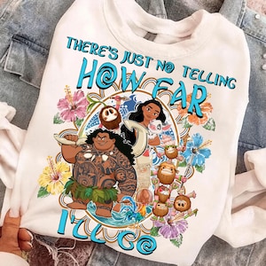 Op de afbeelding: Een wit sweatshirt met ronde hals voorzien van een grafische print van personages uit de film Moana, waaronder Moana, Maui, Pua, Heihei en Kakamora, omringd door kleurrijke hibiscusbloemen en de tekst There's just no telling how far I'll go.