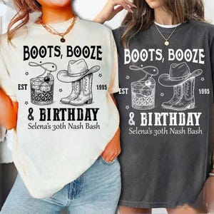 Puede incluir: Dos camisetas, una crema y otra carbón, con un diseño gráfico. El diseño incluye el texto "BOOTS, BOOZE & BIRTHDAY" con un sombrero de vaquero, botas y una copa de cóctel. También se incluye el texto "EST 1995" y "Selena's 30th Nash Bash".