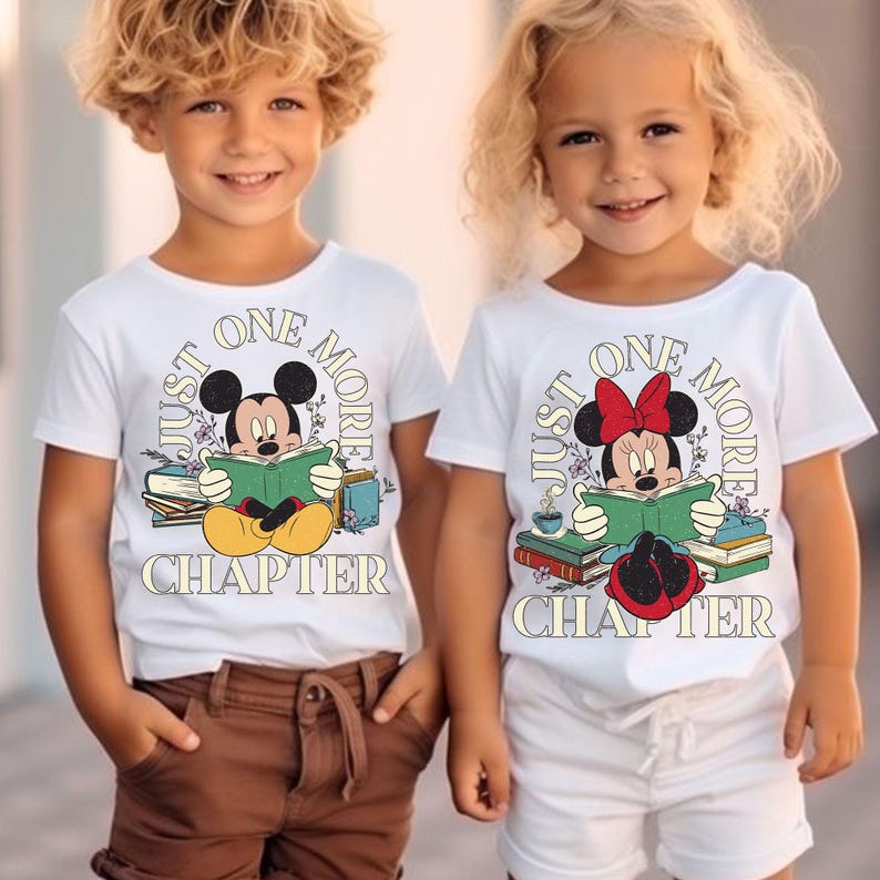 Op de afbeelding: Twee kinderen dragen witte T-shirts met een Mickey Mouse en Minnie Mouse afbeelding. De shirts zeggen "Just One More Chapter" met een stapel boeken en bloemen rond de personages.
