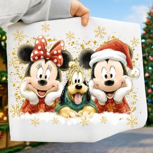 May include: A white print featuring Mickey Mouse, Minnie Mouse, and Pluto in festive attire. Minnie wears a red bow with white polka dots, Mickey dons a Santa hat, and Pluto is in a green sweater. Gold snowflakes and glitter add a holiday touch.