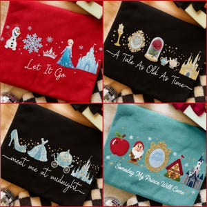 Puede incluir: Cuatro bolsas de mano bordadas en rojo, negro y verde azulado. Cada bolsa presenta un diseño diferente con el texto: "Let It Go", "A Tale As Old As Time", "meet me at midnight" y "Someday My Prince Will Come". Los diseños incluyen personajes de dibujos animados y castillos.