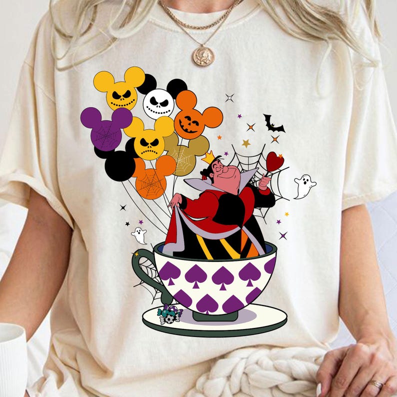 Pu&ograve; includere: T-shirt color crema con design a tema Halloween. La grafica presenta la Regina di Cuori in una tazza da t&egrave;, circondata da palloncini a forma di Mickey Mouse, pipistrelli, stelle e fantasmi. La tazza da t&egrave; ha un motivo a picche viola.