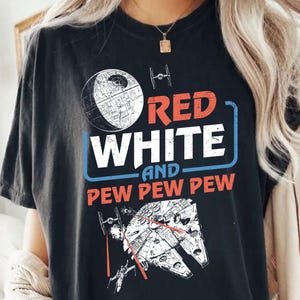 May include: Black t-shirt with a white and red graphic design featuring the words "Red White and Pew Pew Pew" and a spaceship and Death Star.