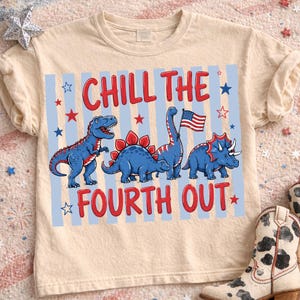 Pode incluir: Camiseta bege com um gráfico de quatro dinossauros azuis com detalhes vermelhos, incluindo um dinossauro segurando uma bandeira americana. O texto "CHILL THE FOURTH OUT" é impresso em vermelho. A camisa tem gola redonda e mangas curtas.