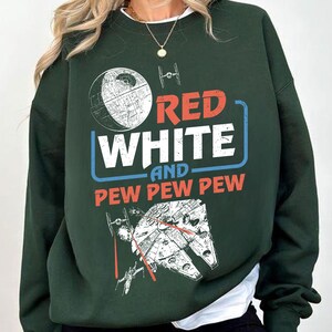 May include: Green sweatshirt with a white and red graphic print that says "Red White and Pew Pew Pew". The graphic also includes a star wars inspired spaceship and a Death Star.