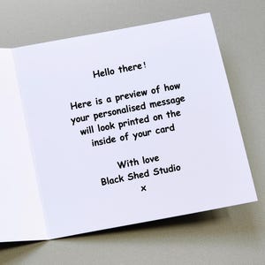 Puede incluir: Tarjeta de felicitaci&oacute;n blanca abierta con texto negro. El texto dice: "&iexcl;Hola! Aqu&iacute; hay una vista previa de c&oacute;mo se ver&aacute; su mensaje personalizado en el interior de su tarjeta. Con amor Black Shed Studio x."