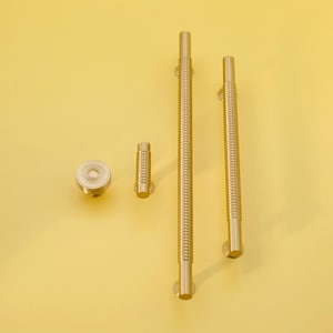 May include: Four gold-toned cabinet hardware pieces, including two long pulls, a short pull, and a round knob. The pulls have a ribbed texture.