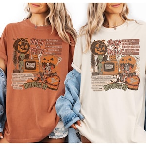 May include: Two t-shirts, one rust-colored and one cream-colored, feature a Halloween-themed graphic. The design includes a jack-o'-lantern, alien, and the text "Trick or Treat" and "Fright Night". The text "October 31" is also present.