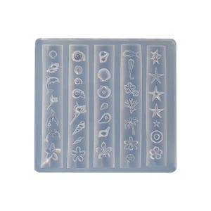 Pode incluir: Um molde de silicone transparente com várias formas com tema oceânico. O molde apresenta desenhos de conchas, estrelas do mar, cavalos-marinhos e flores. O molde é retangular com cinco colunas verticais de formas diferentes.
