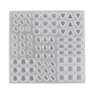 Puede incluir: Un molde de silicona transparente con varias formas para hacer joyas de resina. El molde incluye círculos, óvalos, corazones, triángulos, diamantes y cuadrados.