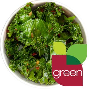 May include: A white bowl filled with a green kale salad with red pepper flakes. The bowl is sitting on a white surface. The text "green" is in the lower right corner of the image.
