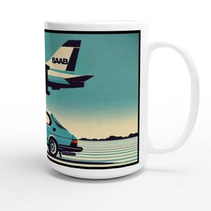 May include: White ceramic mug featuring a retro illustration of a blue Saab car and a Saab airplane against a teal sky. The mug has a black border and a white handle. The word "SAAB" is visible on the airplane.