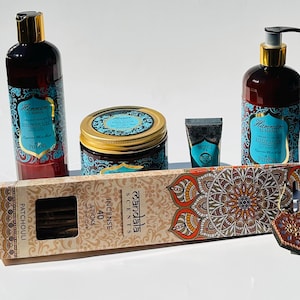 May include: A gift set featuring a blue and gold themed body care products with a Hammam El Hana label. The set includes a body wash, body lotion, body scrub, hand cream, and incense sticks. The incense sticks are labeled "Patchouli" and "40 Sticks".