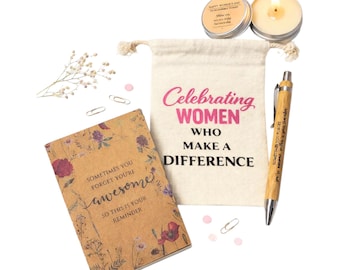 Może przedstawiać: Zestaw upominkowy z płócienną torbą z napisem "Celebrating Women Who Make a Difference", notatnikiem w kwiaty, bambusowym długopisem, świecą i małą puszką. Na notatniku napisano "Sometimes you forget you're awesome, so this is your reminder."