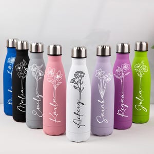 Könnte beinhalten: Eine Sammlung isolierter Wasserflaschen in verschiedenen Farben, darunter Blau, Schwarz, Grau, Rosa, Weiß, Lila und Grün. Jede Flasche hat ein Blumendesign und einen Namen in weißer Schrift. Die Flaschen haben silberne Deckel.
