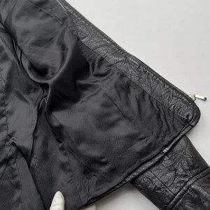 以下が含まれることがあります： 黒い革のジャケットで、ジッパーで閉めることができます。黒い裏地が付いています。ジャケットは裏返して裏地を見ることができます。
