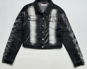 May include: A black and white denim jacket with a faded design. The jacket has a button closure and two pockets on the chest.