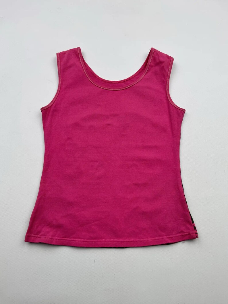 May include: A sleeveless pink tank top with a scoop neck.