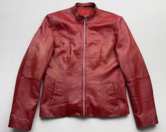 Puede incluir: Una chaqueta de cuero roja con cierre de cremallera y dos bolsillos.
