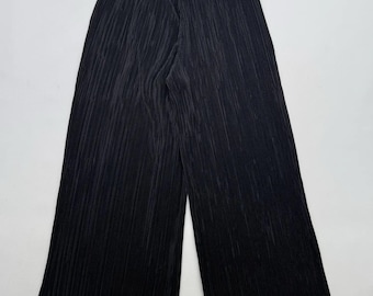 May include: Black pleated wide-leg pants with a drawstring waistband.