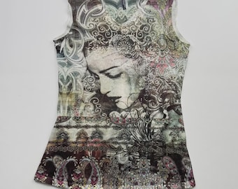 May include: A sleeveless white tank top with a colorful, abstract print featuring a woman's face and intricate patterns. The print is in shades of brown, green, pink, and purple.