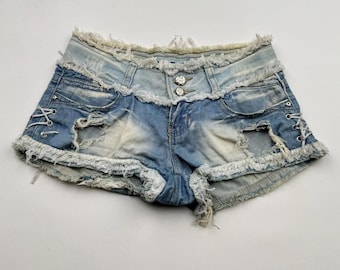 May include: Light blue denim shorts with frayed edges and distressed details. The shorts have a high waist and a lace-up detail on the sides.