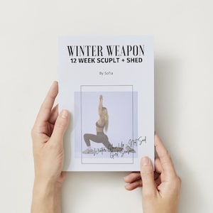 Könnte beinhalten: Ein weißes Büchlein mit dem Titel „WINTER WEAPON 12 WEEK SCULPT + SHED“, das von Händen gehalten wird. Das Büchlein zeigt ein Bild einer Person in Trainingskleidung. Der Text auf dem Büchlein enthält „By Sofia“ und den handgeschriebenen Text „Winter Glow Up - Not Sad Girl Season“.
