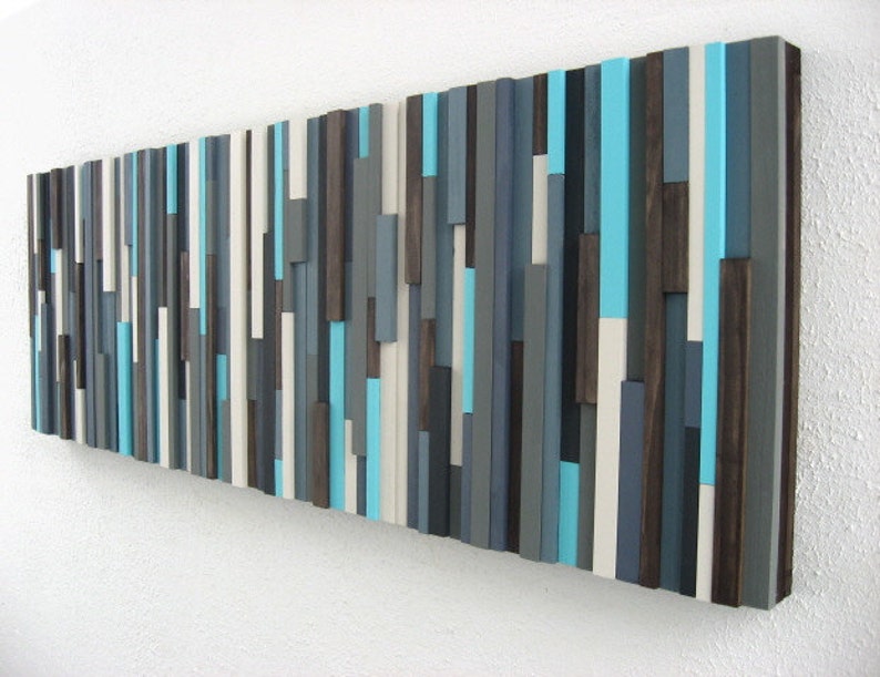 Pu&ograve; includere: Arte da parete astratto realizzato in legno con una variet&agrave; di tonalit&agrave; di blu, grigio e bianco. Il legno &egrave; disposto in uno schema verticale, creando un aspetto moderno e minimalista.