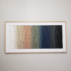 May include: A framed wood wall art piece with a gradient of colors from white to black. The wood is arranged in a vertical pattern, creating a textured effect.