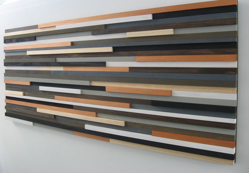 May include: A wall art piece made of various wood planks in shades of brown, gray, white, and orange. The planks are arranged in a horizontal pattern, creating a modern and abstract design.