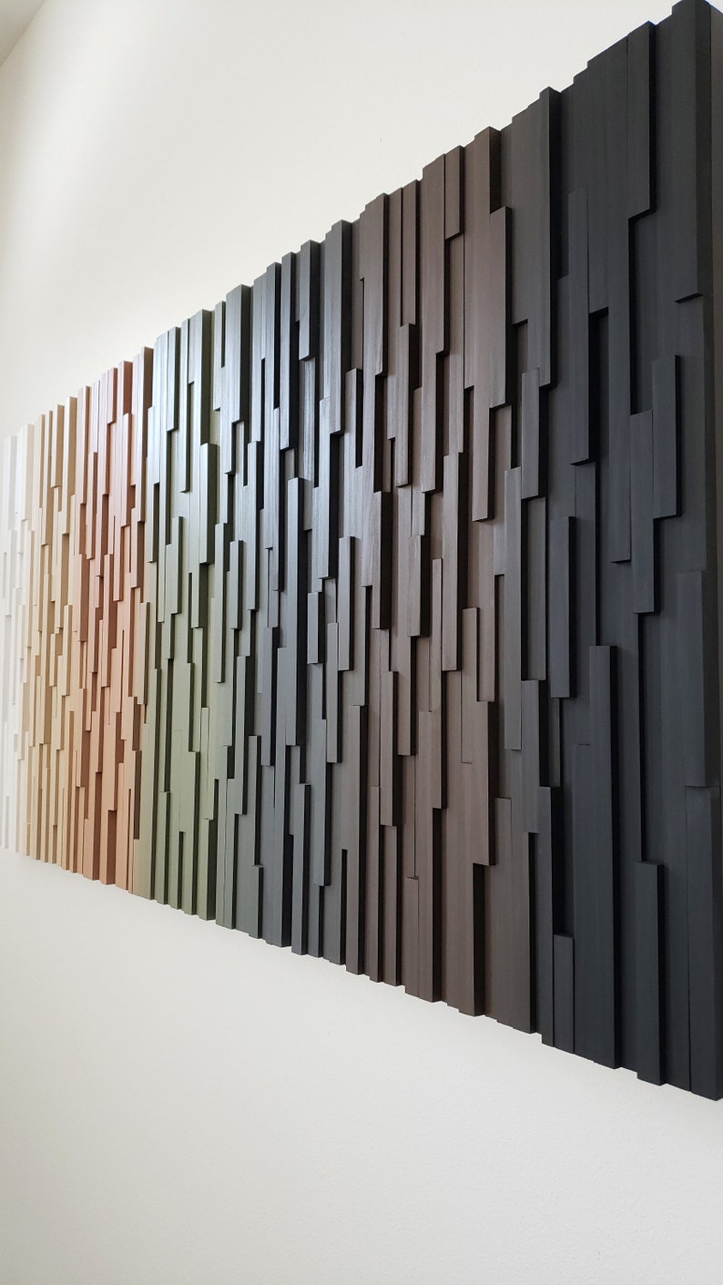 May include: A wall art piece made of wood with a gradient of colors from white to black. The wood is arranged in a staggered pattern, creating a textured surface.