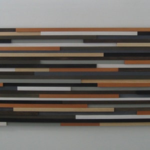 May include: A wall art piece made of wood slats in various shades of brown, gray, and white. The slats are arranged in a horizontal pattern, creating a modern and abstract design.
