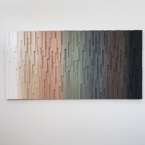 May include: A wall art piece made of wood with a gradient of colors from white to black. The wood is arranged in a vertical pattern, creating a textured effect.