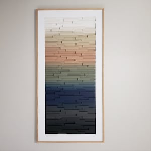 May include: A framed abstract wall art piece with a gradient of colors from white to black. The artwork is made of wood blocks stacked in a staggered pattern.