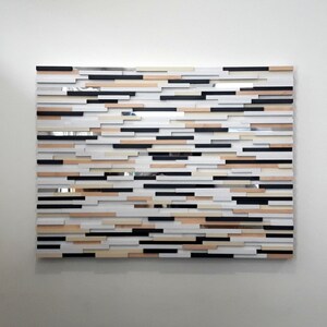 May include: Abstract wall art made of wood and mirror tiles in black, white, and beige.