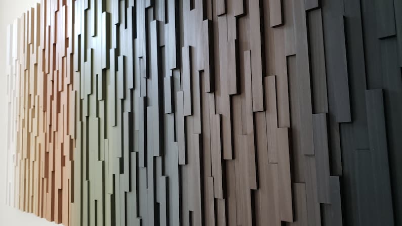 May include: A wall covered in a gradient of wood panels, ranging from light beige to dark brown. The panels are arranged in a staggered pattern, creating a textured and modern look.
