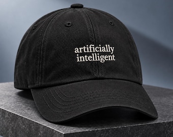 May include: A black baseball cap featuring the white embroidered text "artificially intelligent" centered on the front panel. The cap has a structured crown, a curved brim, and stitched eyelets for ventilation, presenting a clean and simple design.